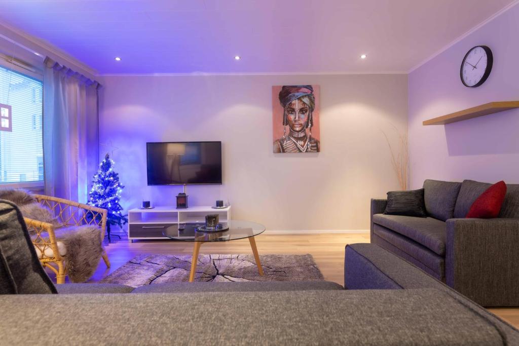 ein Wohnzimmer mit Sofa und Weihnachtsbaum in der Unterkunft Apartment Rovakatu D28 in Rovaniemi