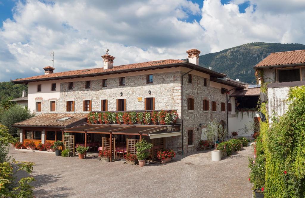 un gran edificio de piedra con flores delante en Agriturismo I Comelli en Nimis