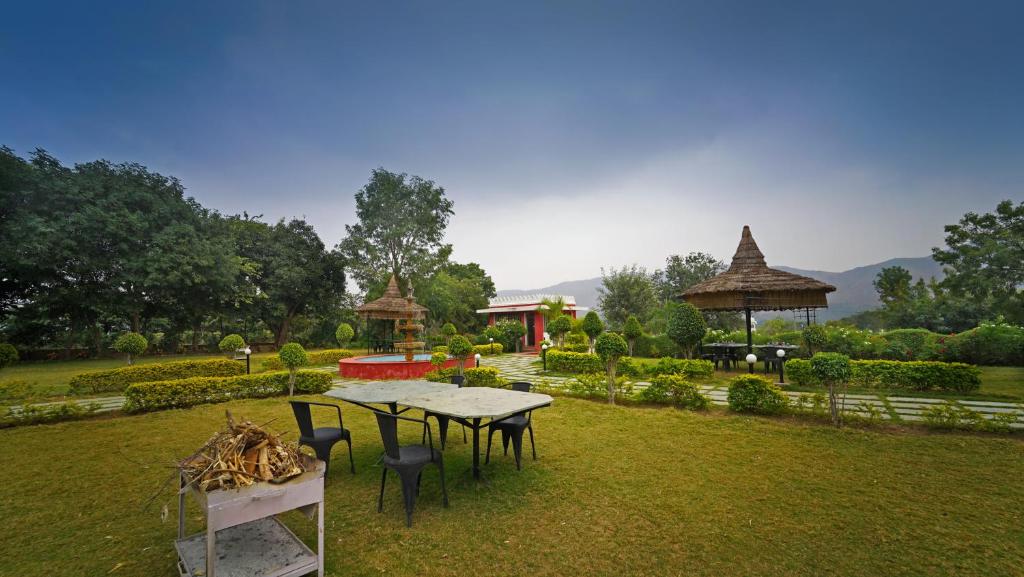 a garden with a table and chairs in the grass at The Lal Bagh in Kumbhalgarh