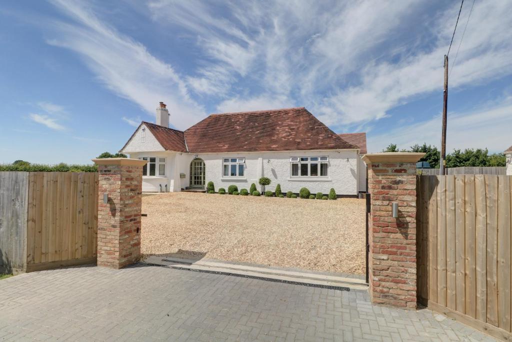 a white house with a gate and a fence at The Little Paddock in Malmesbury