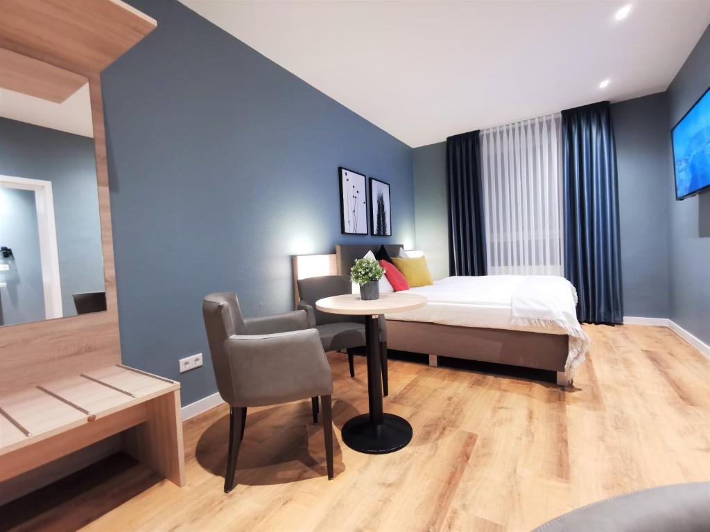 1 dormitorio con 1 cama, 1 mesa y 1 silla en Hotel Restaurant Verst, en Gronau