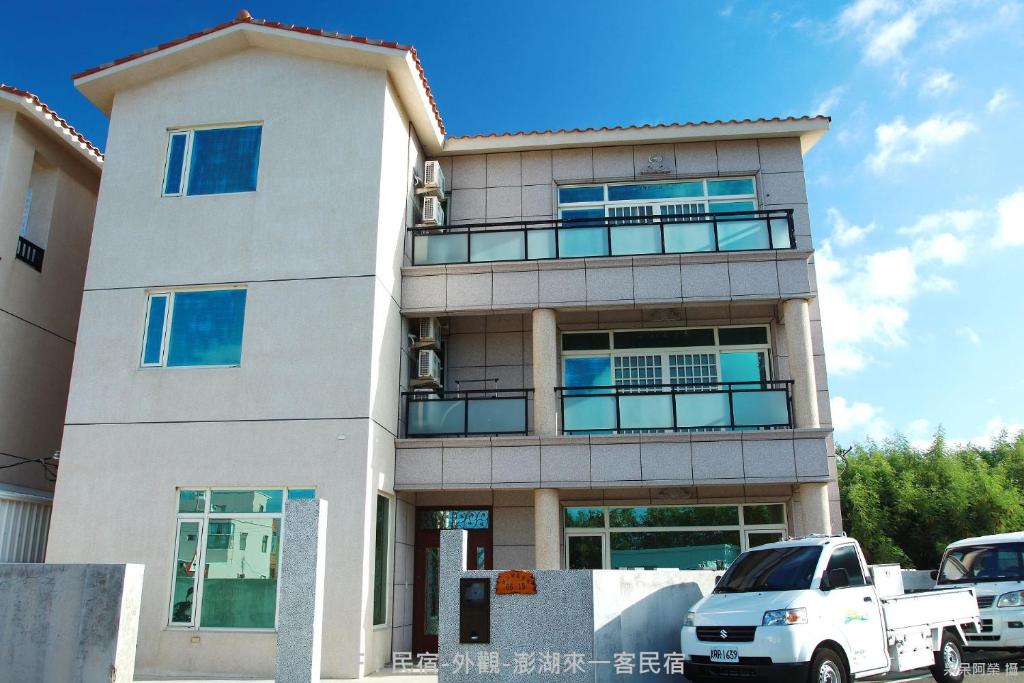 un camión blanco estacionado frente a un edificio en Lai Yi Ke Homestay, en Baisha