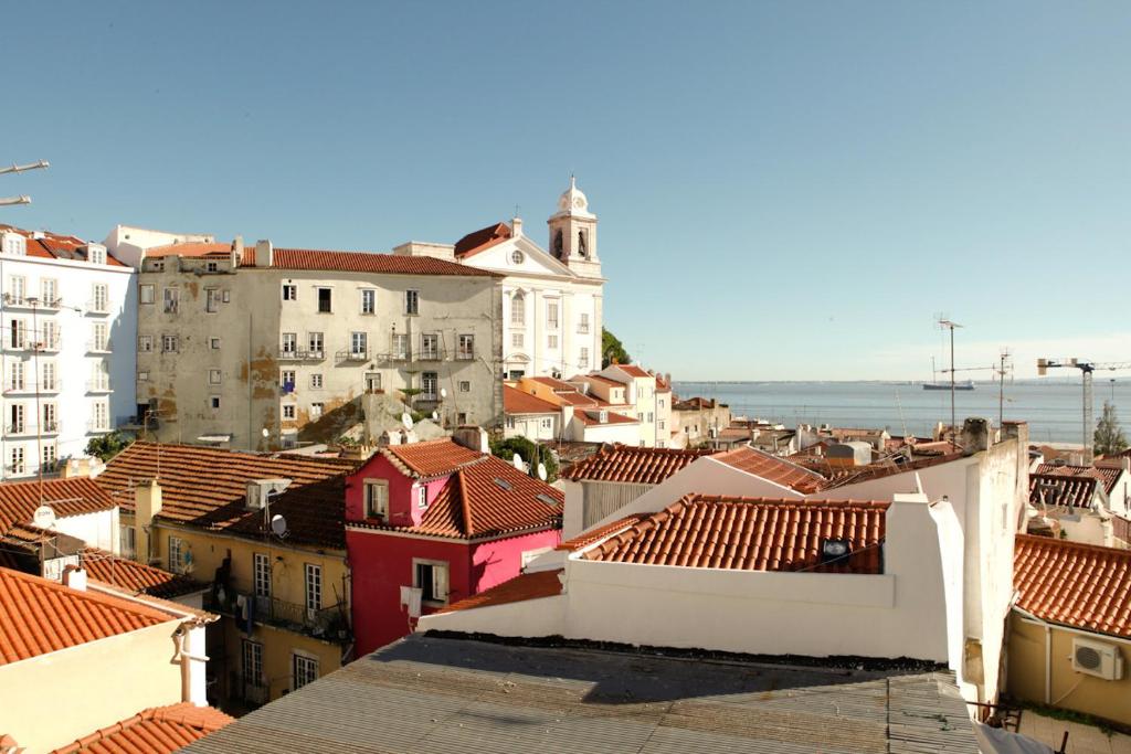 リスボンにあるBest Terrace River View Apt in Alfamaの建物と海を望む市街の景色