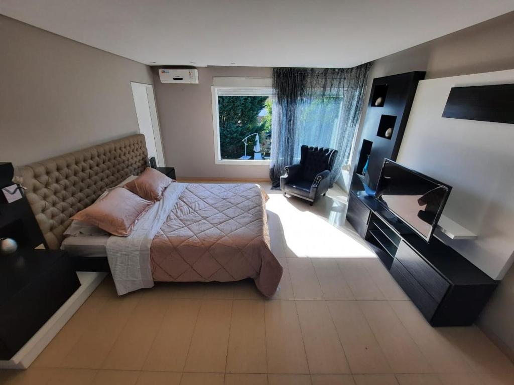 a bedroom with a bed and a window and a television at Casa Guemes in Mar del Plata