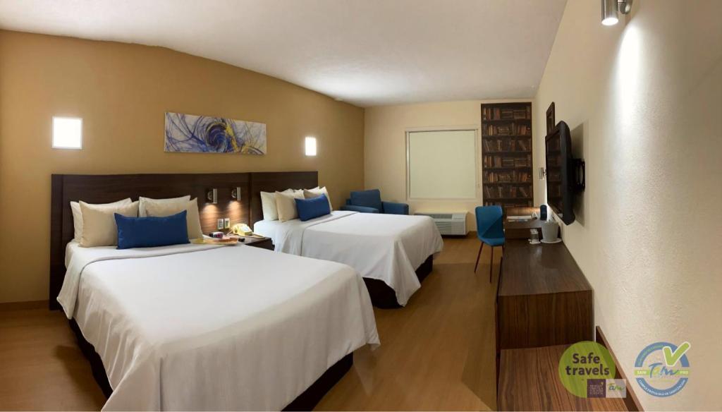 a hotel room with two beds and a television at Rio Vista Inn Business High Class Tampico in Tampico