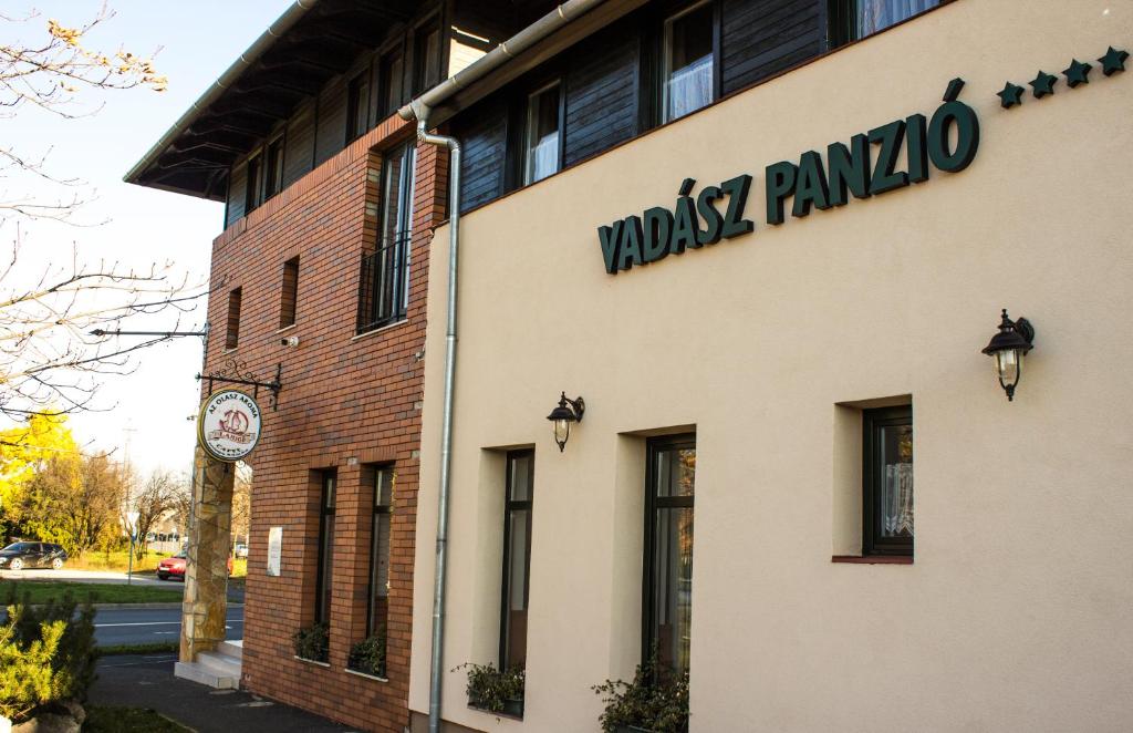 a building with a sign on the side of it at Vadász Panzió és Étterem in Szombathely