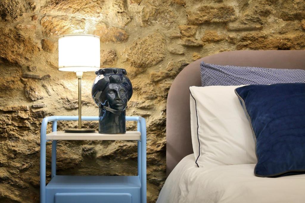 una cama con una lámpara en una mesa junto a una cama en B&B RONCO ZAFFARANA, en Caltagirone
