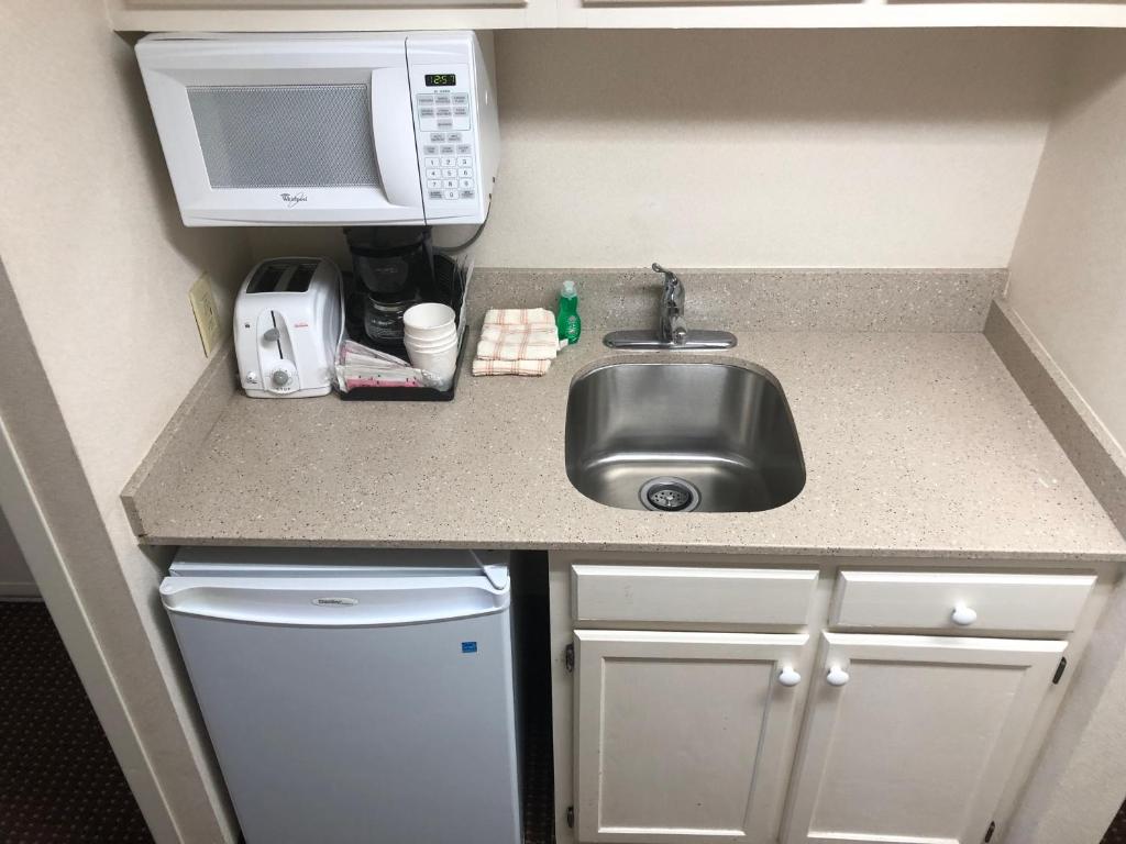 a small kitchen with a sink and a microwave at Comfort Inn Ocean City Boardwalk in Ocean City