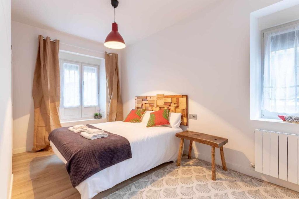 - une chambre avec un lit et une tête de lit en bois dans l'établissement Apartamento KUIA en Gran Bilbao con terraza y vistas a un parque, à Basauri