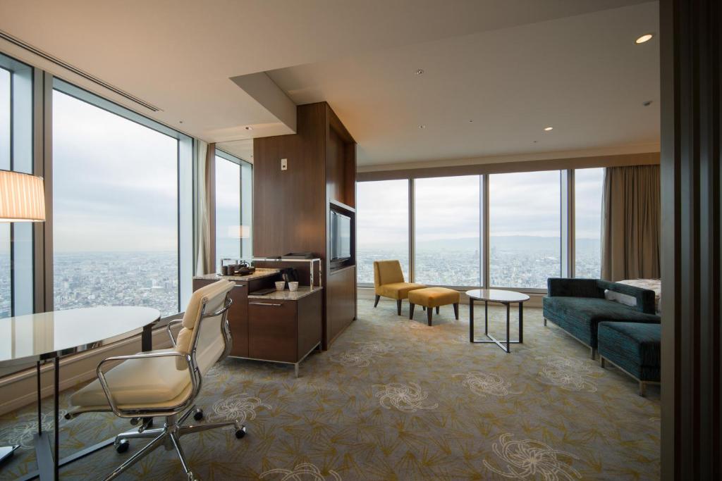 a living room with a couch and a table and chairs at Osaka Marriott Miyako Hotel in Osaka