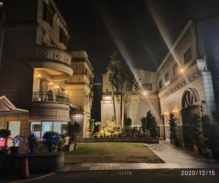 a large building with a courtyard at night at I Travel Motel - II in Kaohsiung