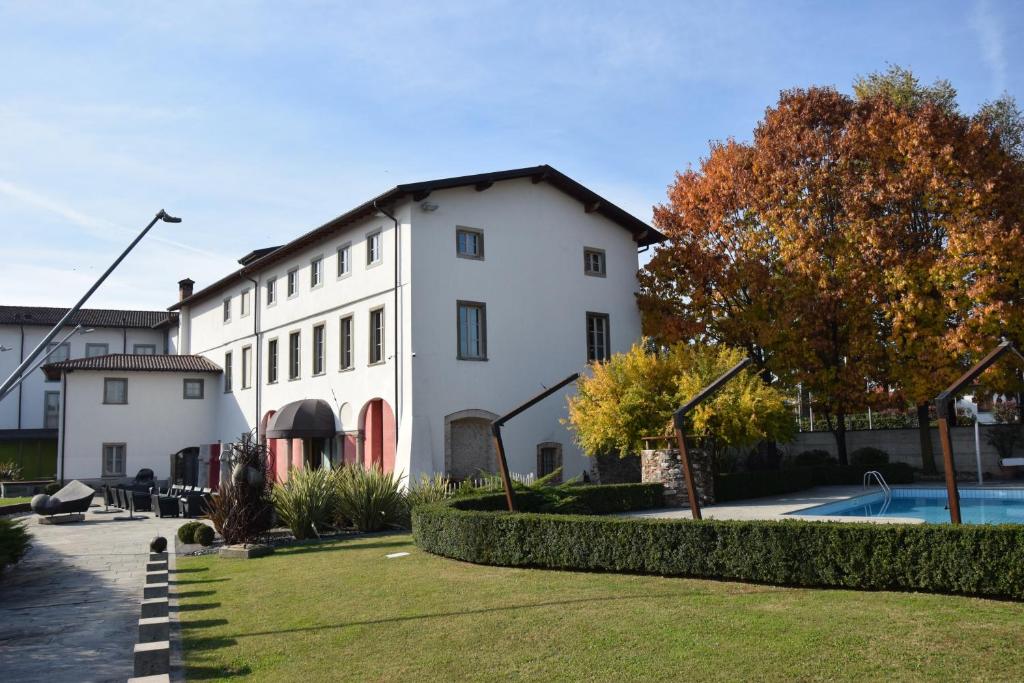 a large white building with a pool in front of it at Settecento Hotel in Presezzo