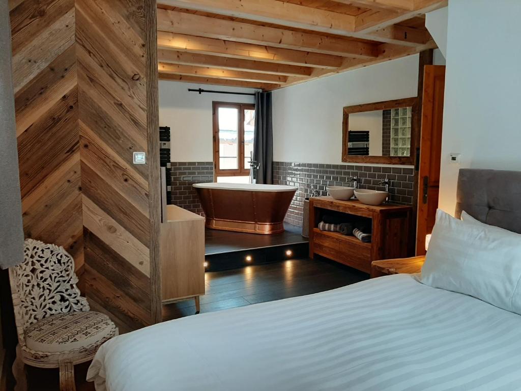 ein Schlafzimmer mit einem Bett und einer Badewanne im Bad in der Unterkunft Chalet Beaufort in Saint-Martin-de-Belleville