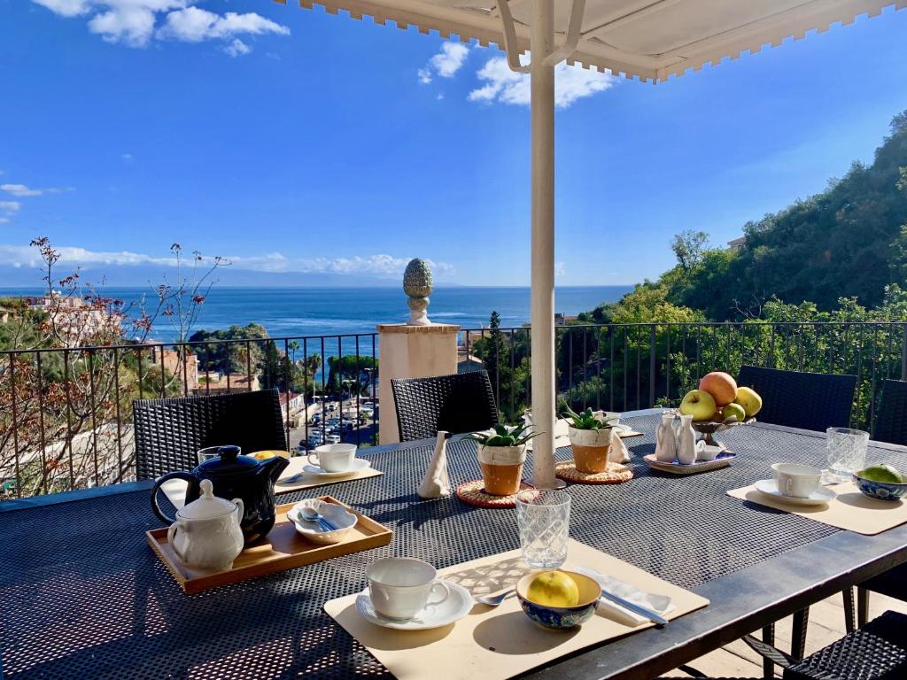 - une table à manger avec vue sur l'océan dans l'établissement Villa Don Giovanni Taormina Mare, à Taormine