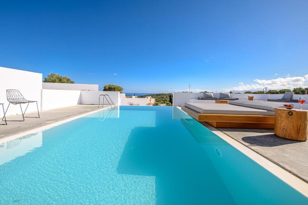 - une piscine d'eau bleue dans une maison dans l'établissement Cocoon Luxury Villas, à Chersónissos