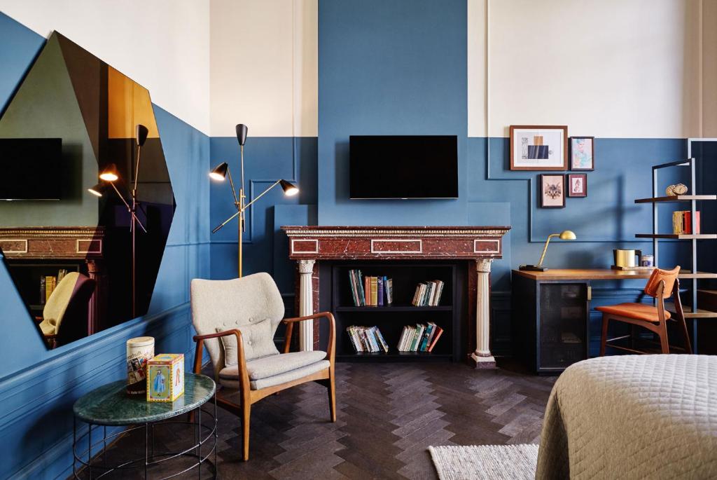 a room with a bed and a fireplace and a tv at The Hoxton, Amsterdam in Amsterdam