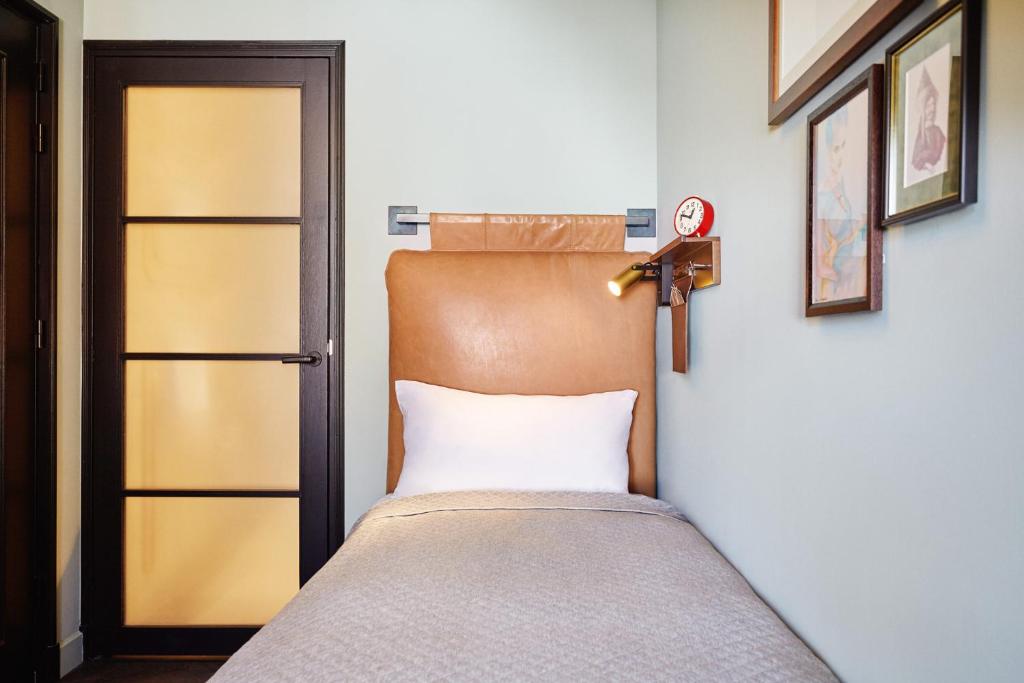 a small bedroom with a bed and a door at The Hoxton, Amsterdam in Amsterdam
