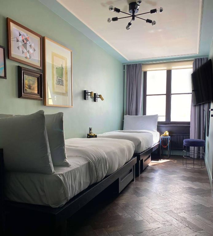a hotel room with two beds and a window at The Hoxton, Amsterdam in Amsterdam