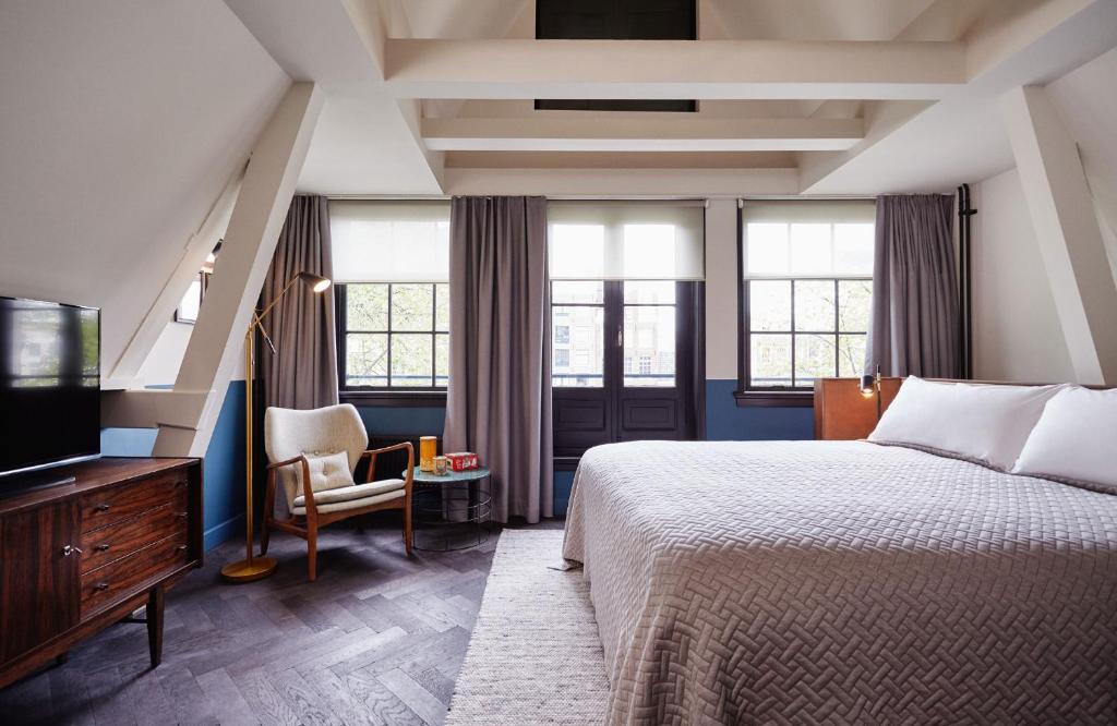 a hotel room with a bed and a television at The Hoxton, Amsterdam in Amsterdam