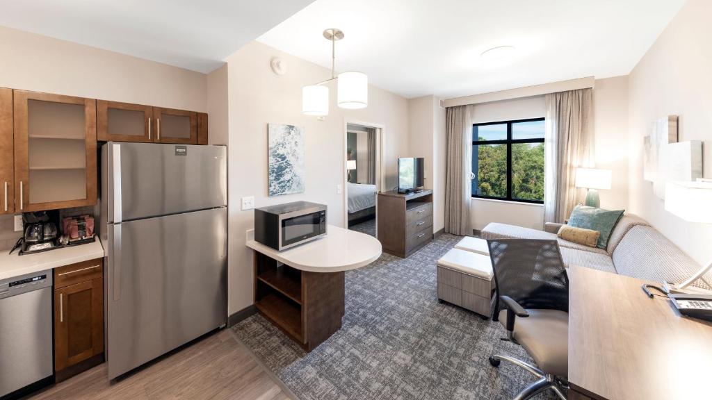 a kitchen and living room with a stainless steel refrigerator at Staybridge Suites - Naples - Marco Island by IHG in Naples