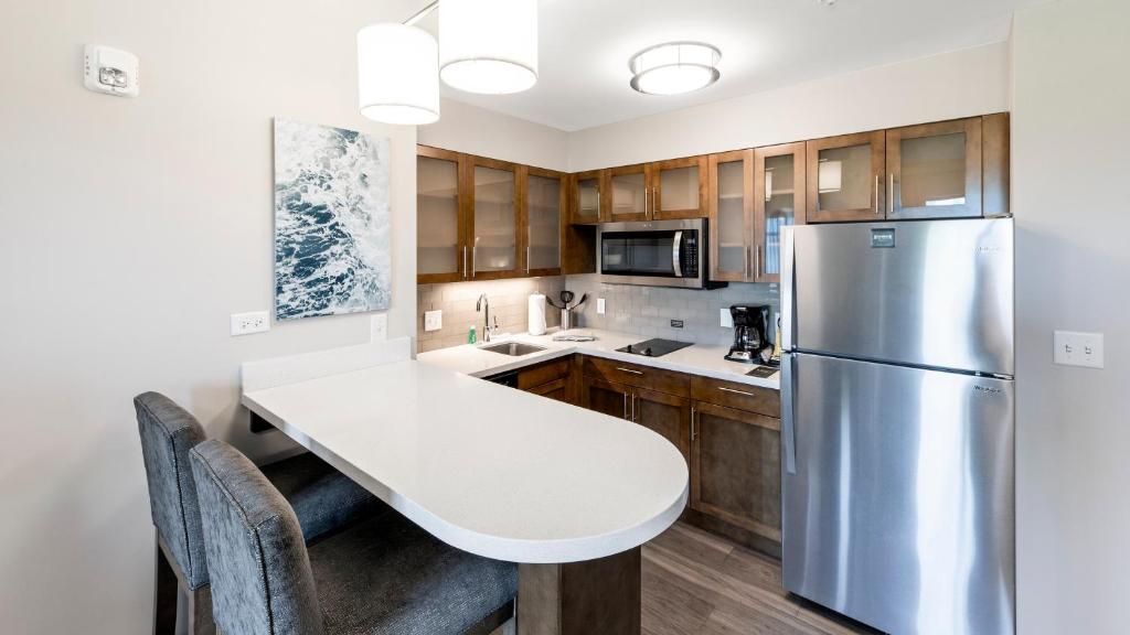 a kitchen with a white table and a refrigerator at Staybridge Suites - Naples - Marco Island by IHG in Naples
