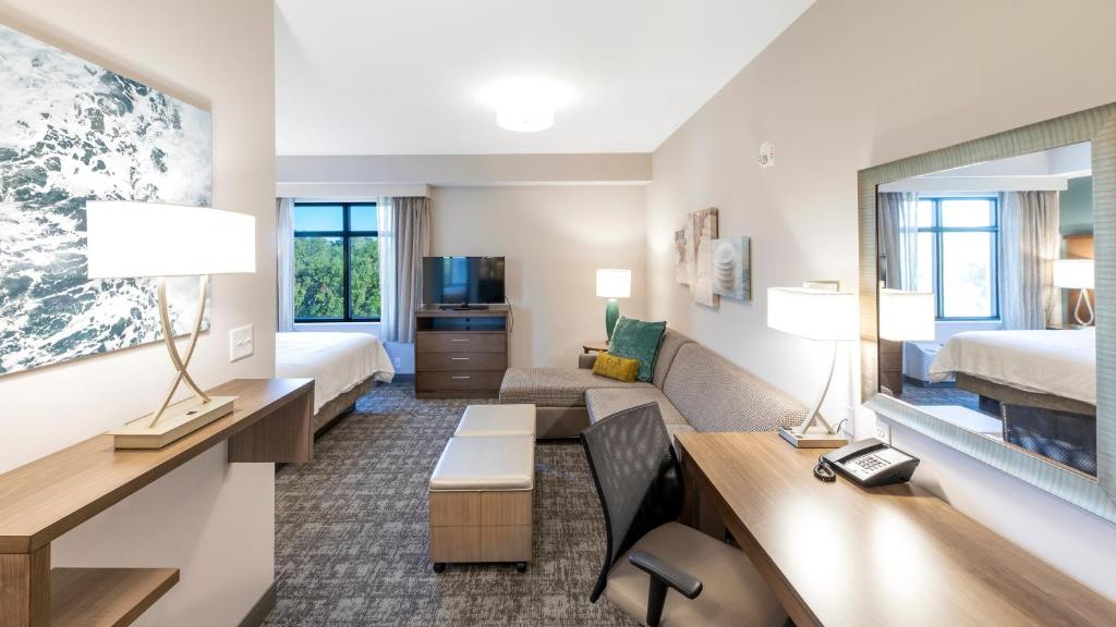 a hotel room with a bedroom and a living room at Staybridge Suites - Naples - Marco Island by IHG in Naples