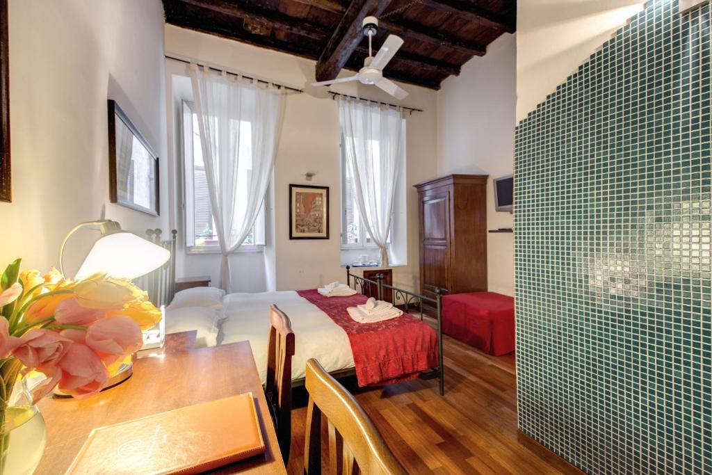 ローマにあるNova Domiziaのベッド1台、テーブル、ダイニングルームが備わる客室です。