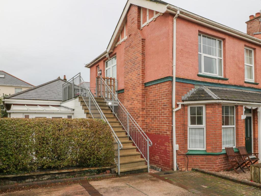 a brick house with a staircase on the side of it at Sea Peeps in Paignton