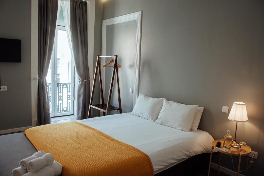 a bedroom with a large bed with a window at The Hygge Lisbon Suites - Estrela in Lisbon