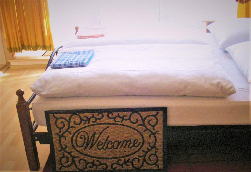 una cama con una señal de bienvenida delante de ella en soukromý pokoj, en Praga