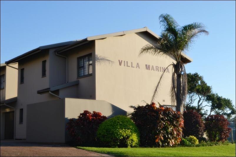 a building with a palm tree in front of it at Unit 6 Villa Marina in Hibberdene