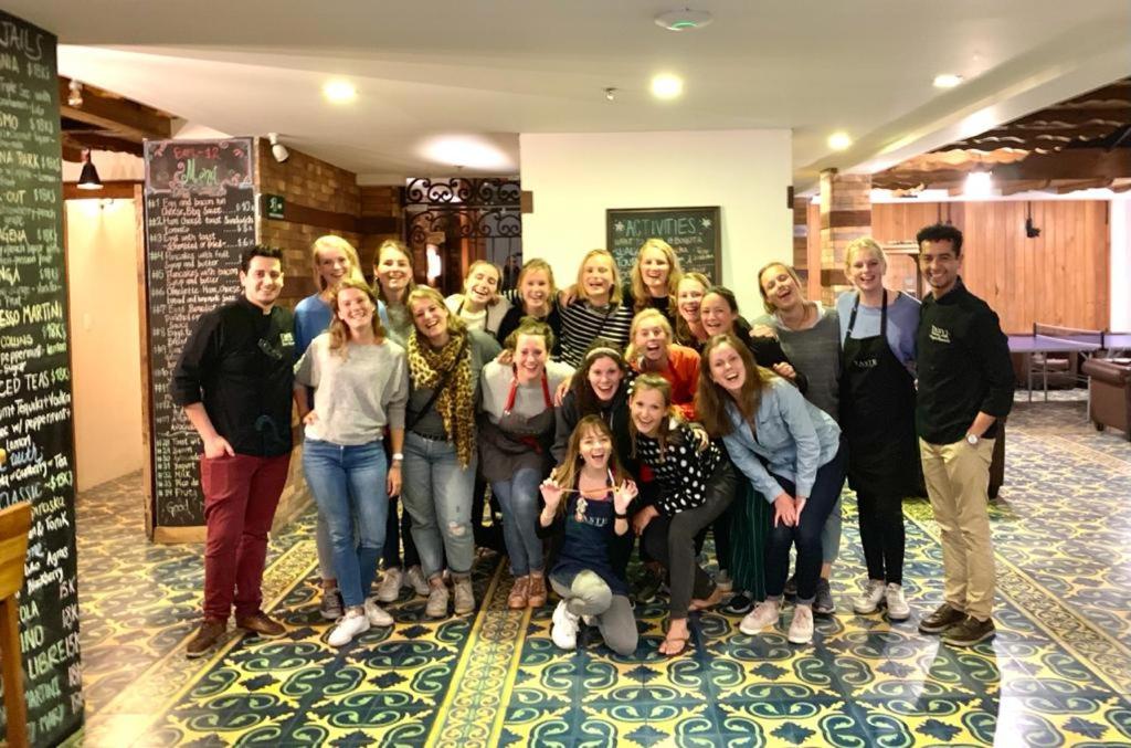 a group of people posing for a picture in a room at The Cranky Croc Hostel in Bogotá