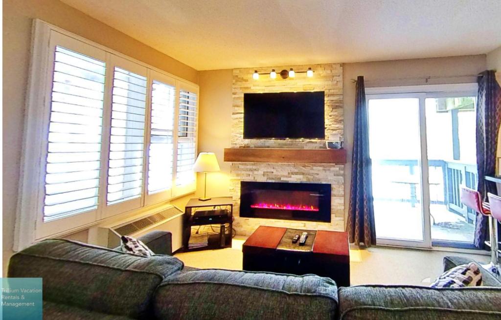 a living room with a couch and a fireplace at Classy Mountainside Studio in Blue Mountains