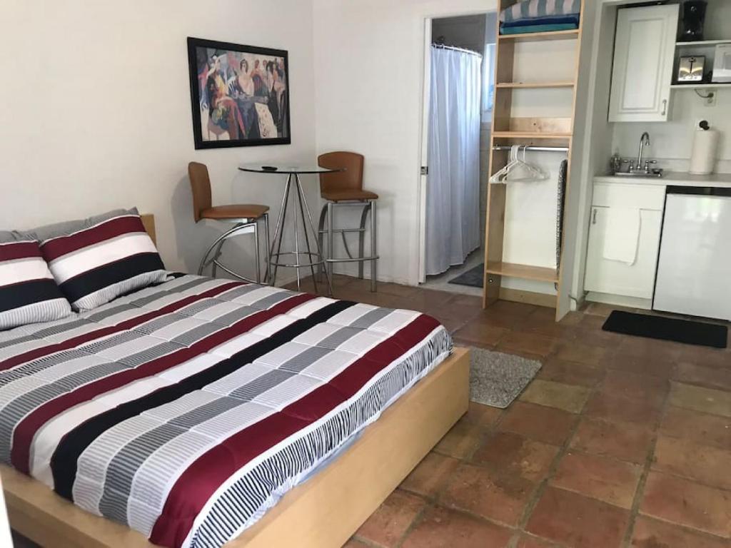 een slaapkamer met een bed en een keuken met stoelen bij Efficiency 2 on water Las Olas, beach and free kayaks in Fort Lauderdale
