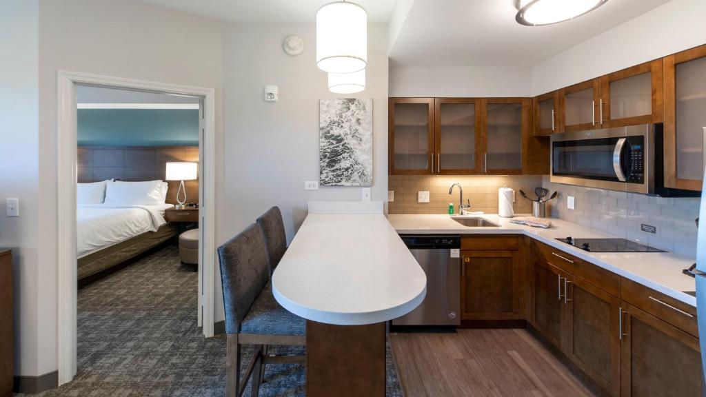 a kitchen with a sink and a bed in a room at Staybridge Suites - Naples - Marco Island by IHG in Naples