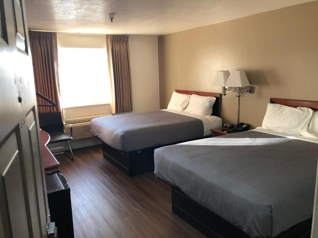 Postel nebo postele na pokoji v ubytování Ameri-Stay Inn & Suites
