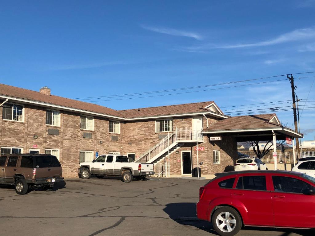 un coche rojo estacionado en un estacionamiento frente a un edificio en Ameri-Stay Inn & Suites en Clearfield