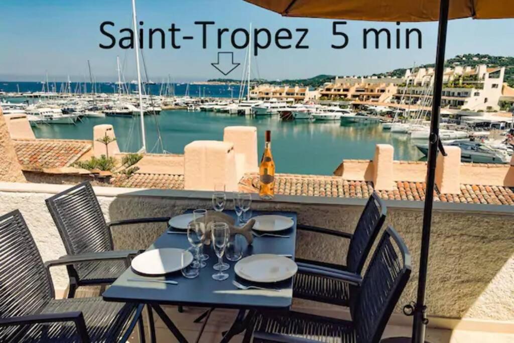 - une table avec des verres à vin sur un balcon avec un port de plaisance dans l'établissement Luxe Penthouse Les Pieds dans l’eau Saint-Tropez 4, à Cogolin