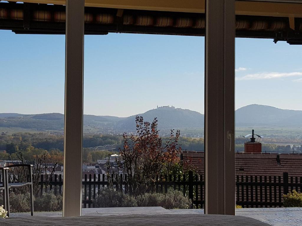 uma vista para as montanhas a partir de um quarto com janelas em Blick über Krems mit Terrasse em Krems an der Donau