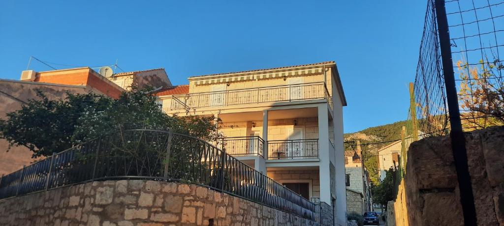 a building with a fence in front of it at Apartments Villa Beba in Komiža