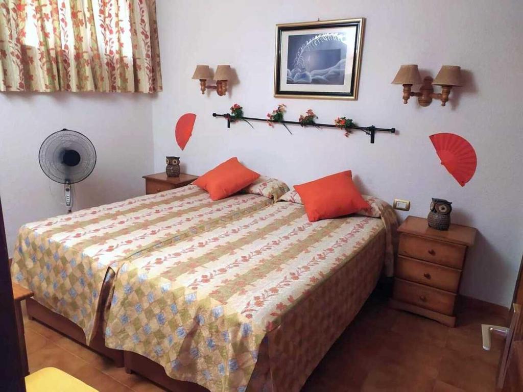 een slaapkamer met een bed met rode kussens erop bij Apartamento Neptuno playa 06 in Puerto de Santiago