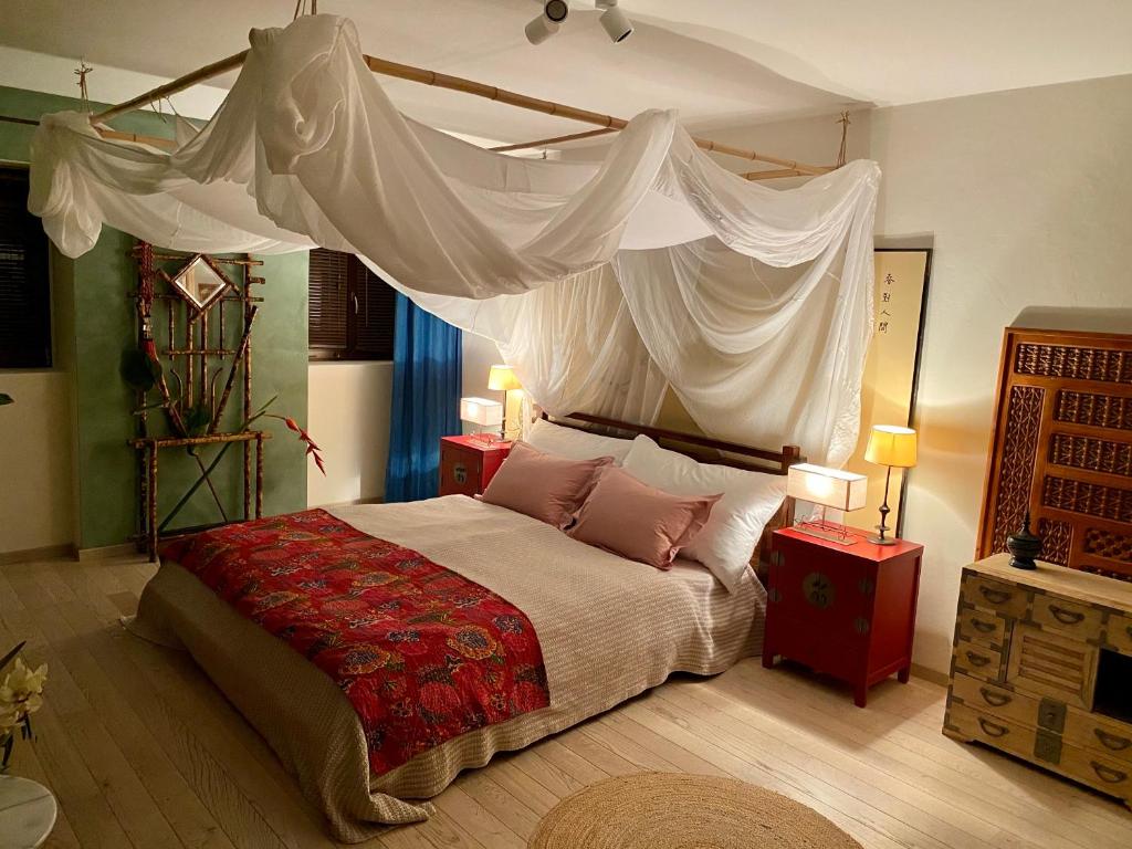 a bedroom with a large bed with a canopy at Les 3 Coeurs - Chambres chez charmants habitants in Font