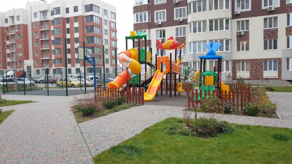 um parque infantil com escorrega num parque com edifícios em Аренда уютной квартиры на сутки с видом на Море и Есть бомбоубежище em Kryzhanivka