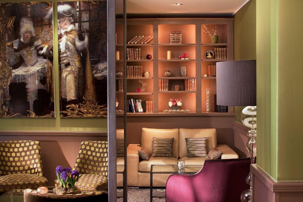 ein Wohnzimmer mit Sofa und Bücherregal in der Unterkunft Hotel Best Western Anjou Lafayette in Paris
