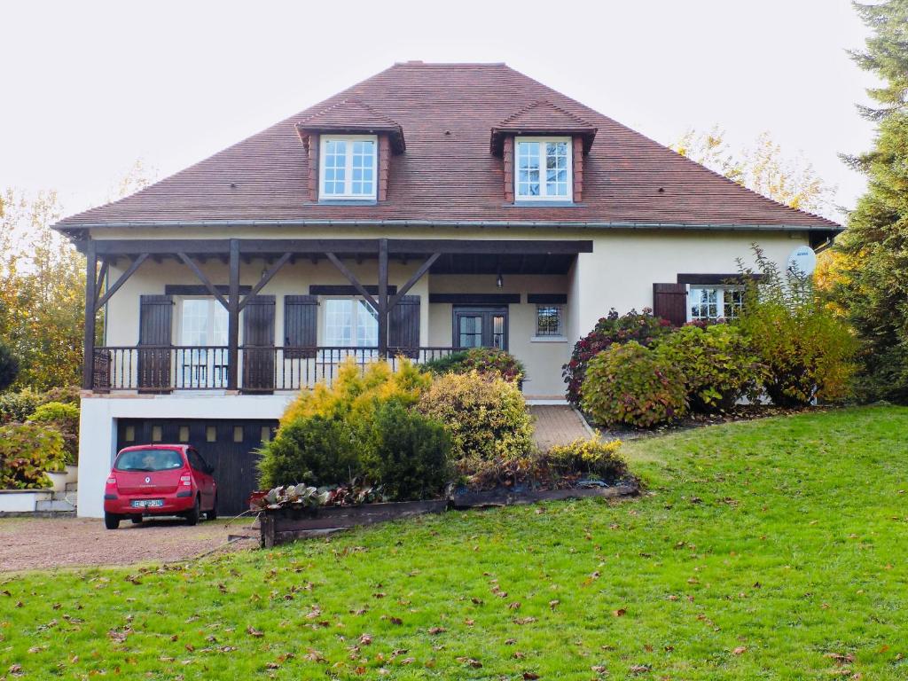 a house with a red car parked in front of it at Charming Country Estate in Dournazac