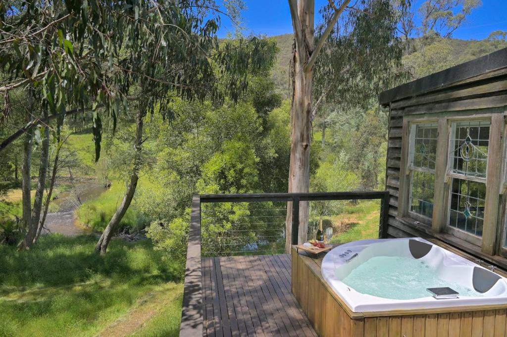 a jacuzzi tub on the deck of a cabin at Toorongo River Chalets in Noojee