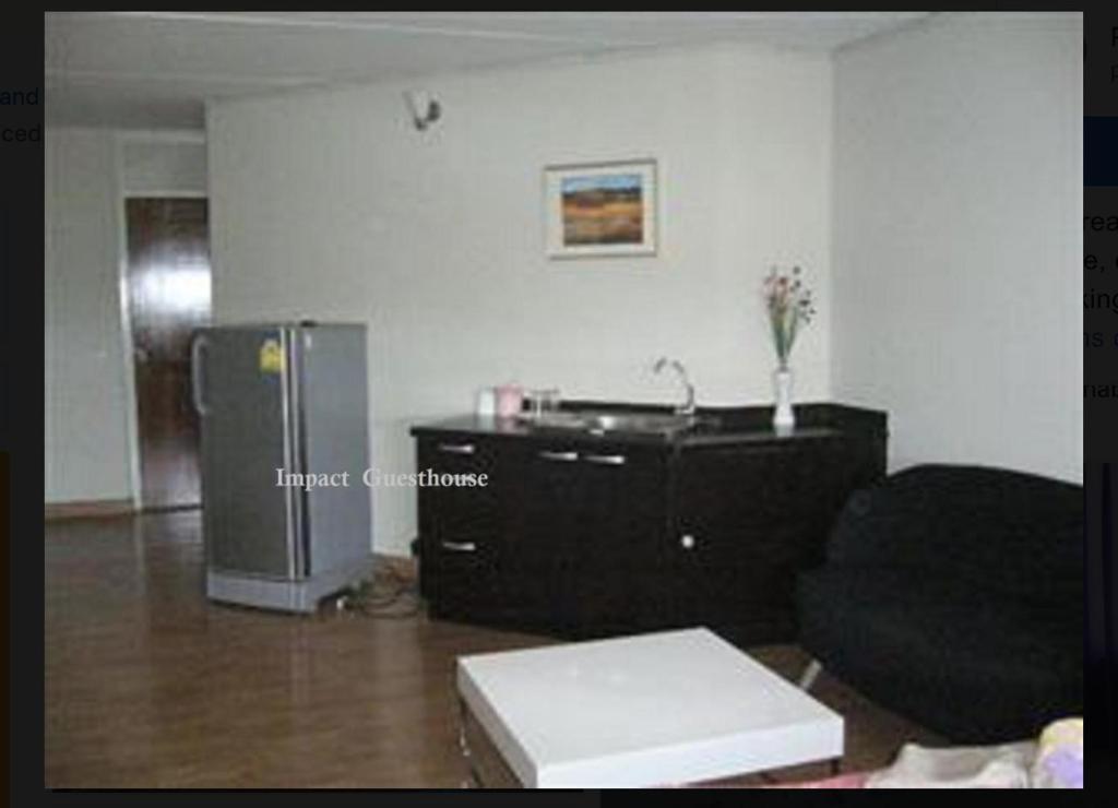 a living room with a couch and a refrigerator at Impact -Challenger Muang thong Thani in Thung Si Kan