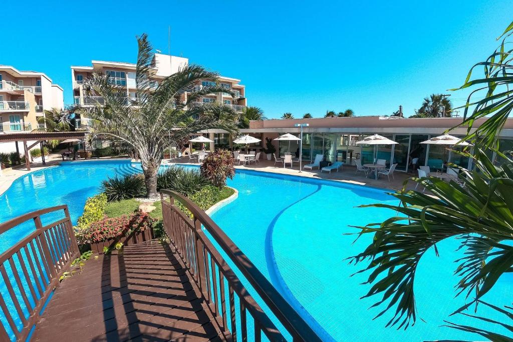 a swimming pool at a resort with a resort at Palm Beach | Porto das Dunas - CE in Aquiraz