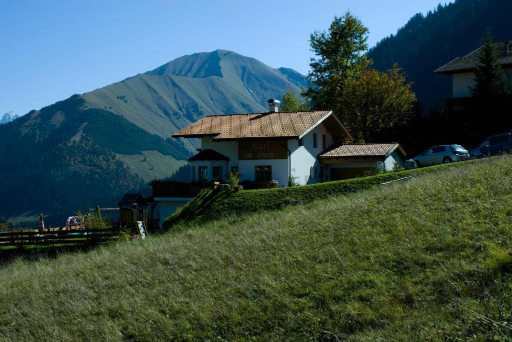 uma casa numa colina com uma montanha ao fundo em Häus`l am Ruan em Berwang