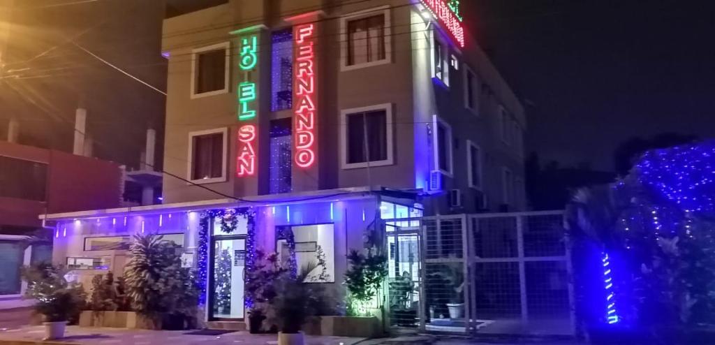 um edifício com sinais de néon na lateral em Hotel San Fernando em Portoviejo